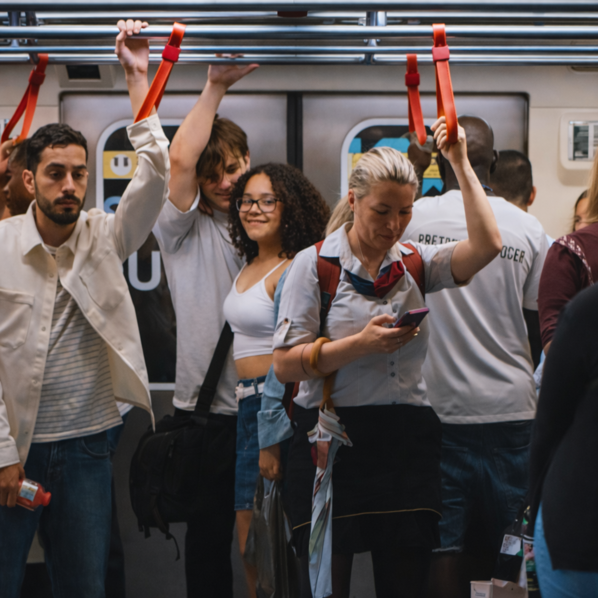 Divers passagers dans une rame de métro ou de train, illustrant la mixité sociale et les transports en commun au quotidien.
